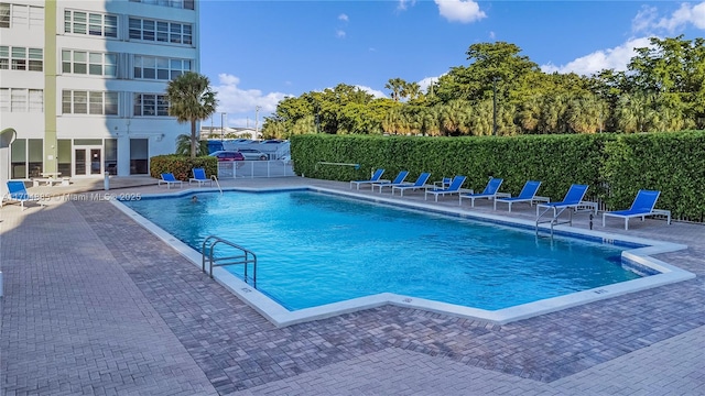 community pool featuring a patio area and fence