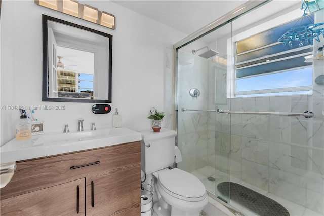 bathroom with vanity, toilet, and a stall shower