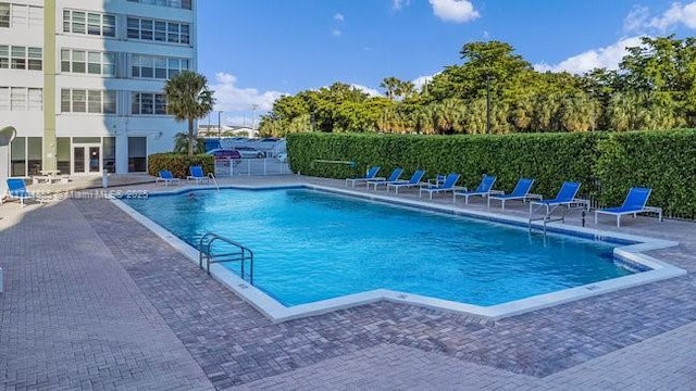 community pool featuring a patio area and fence