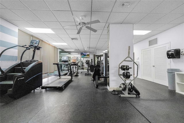 workout area with a ceiling fan, a drop ceiling, and visible vents