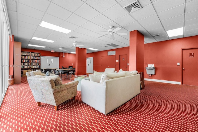 living area featuring ceiling fan, a paneled ceiling, and visible vents