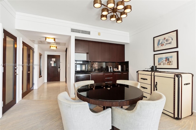 dining area with sink, ornamental molding, and a chandelier