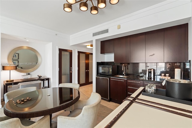 kitchen featuring sink, refrigerator, backsplash, dark brown cabinetry, and ornamental molding