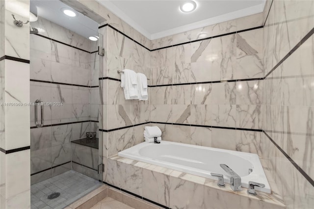 bathroom with tile walls and independent shower and bath