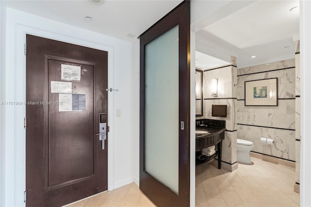 foyer entrance featuring tile walls