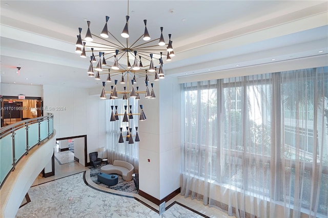 interior space with an inviting chandelier and a tray ceiling