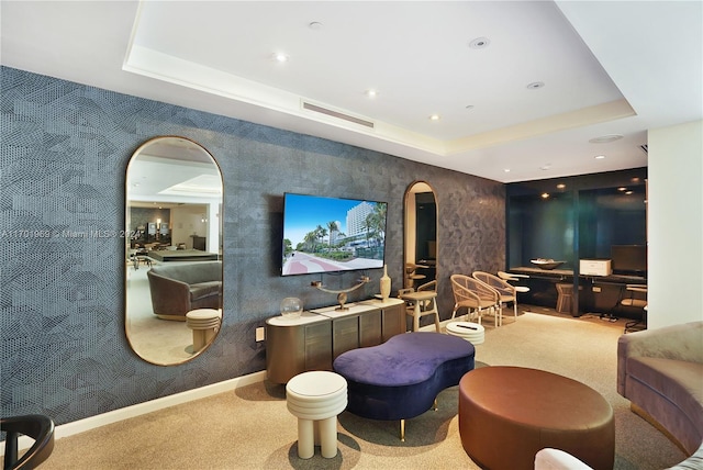 home theater room with light carpet and a tray ceiling