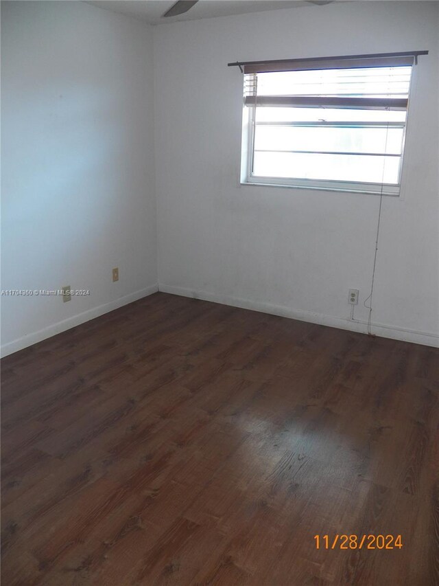 unfurnished room featuring a wealth of natural light and dark wood-type flooring