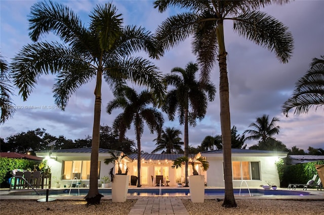 back house at dusk with pool water feature