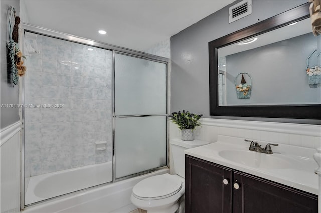 full bathroom with shower / bath combination with glass door, vanity, and toilet