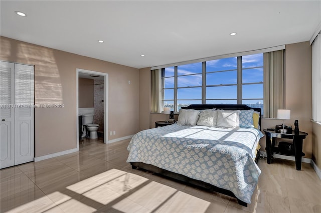 bedroom featuring light tile patterned floors and connected bathroom