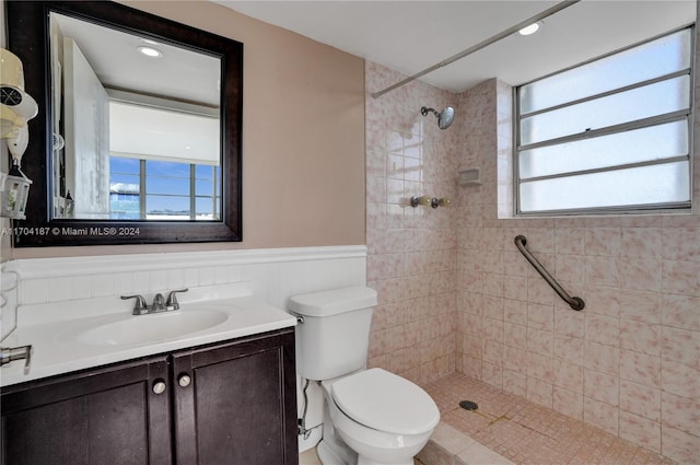 bathroom with vanity, toilet, and tiled shower