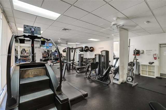 exercise room with a drop ceiling and ceiling fan