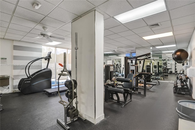 workout area with a paneled ceiling and ceiling fan