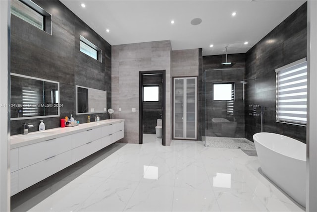 full bathroom with vanity, toilet, tile walls, and independent shower and bath