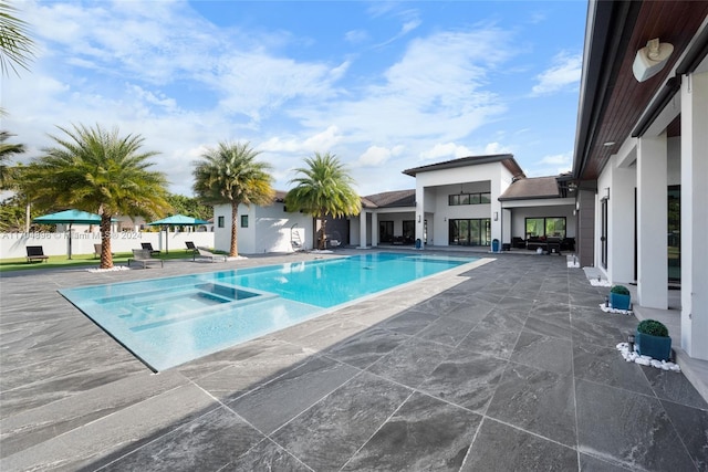 view of swimming pool featuring an in ground hot tub and a patio