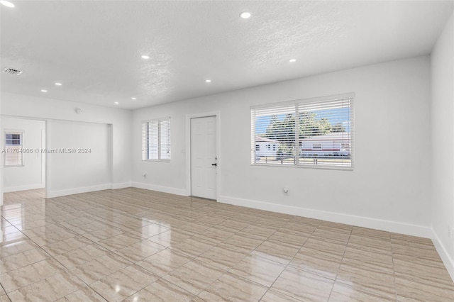 unfurnished room featuring a textured ceiling