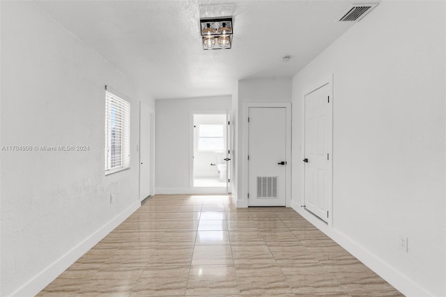 hallway with a textured ceiling and vaulted ceiling