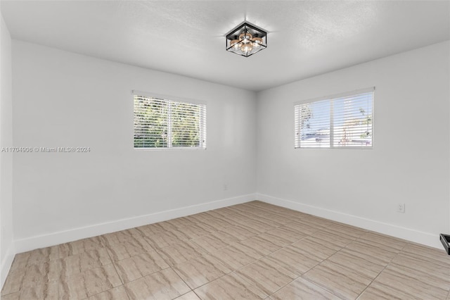 unfurnished room featuring a textured ceiling