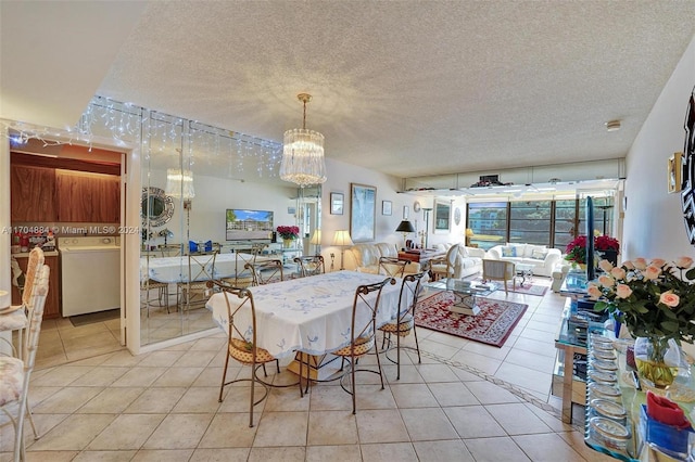 dining space featuring light tile patterned flooring, a textured ceiling, and washer / dryer