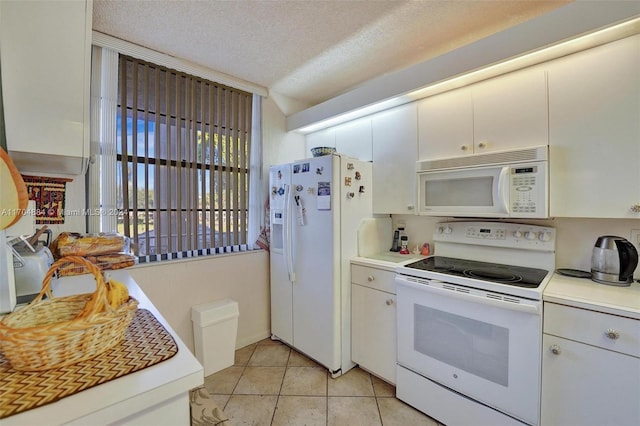 kitchen featuring white cabinetry, light tile patterned flooring, white appliances, and a textured ceiling