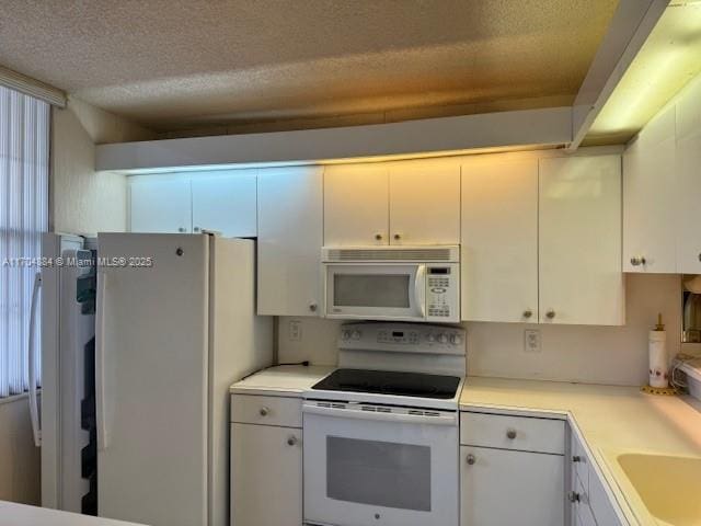 1530 Whitehall Dr Unit 204, Davie, FL 33324 - kitchen with light countertops, a textured ceiling, white cabinetry, and white appliances