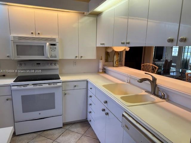 1530 Whitehall Dr Unit 204, Davie, FL 33324 - kitchen with white cabinets, white appliances, light countertops, and a sink