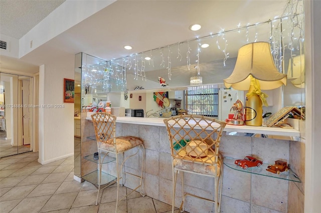 kitchen with a kitchen bar and white fridge