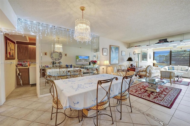 dining space featuring light tile patterned floors, a textured ceiling, and a notable chandelier