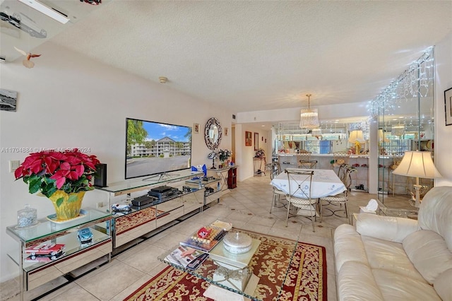 tiled living room featuring a chandelier and a textured ceiling