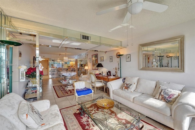 tiled living room featuring ceiling fan and a textured ceiling