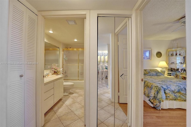 full bathroom with hardwood / wood-style floors, vanity, toilet, and shower / bath combination with glass door