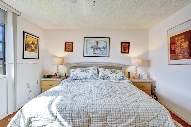 bedroom with wood-type flooring and a textured ceiling