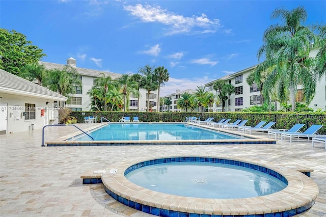 view of pool featuring a community hot tub and a patio