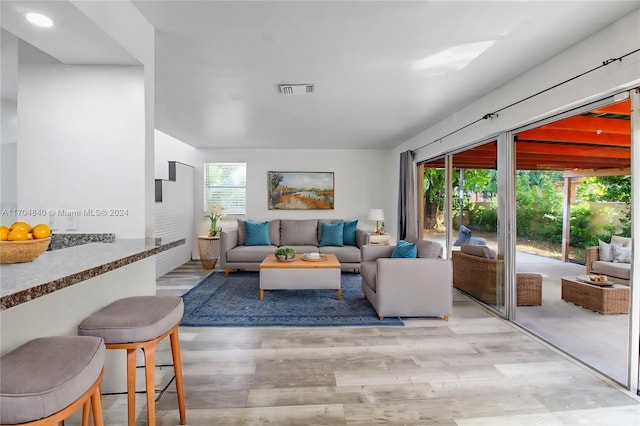 living room featuring plenty of natural light, visible vents, and light wood-style floors