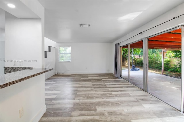 unfurnished room featuring light wood finished floors, baseboards, and visible vents