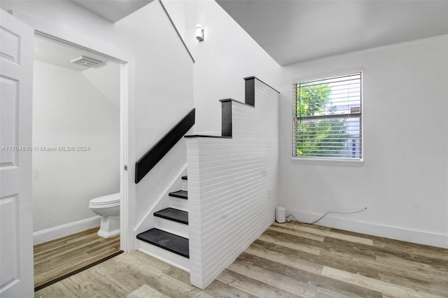 stairway with baseboards and wood finished floors