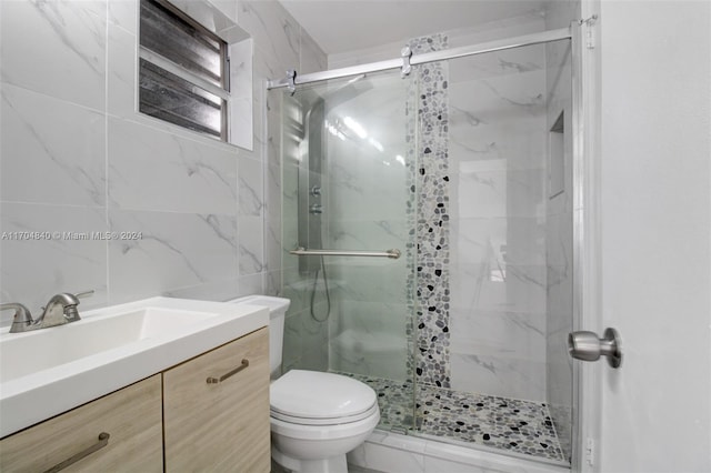 full bathroom featuring toilet, marble finish floor, vanity, a shower stall, and tile walls