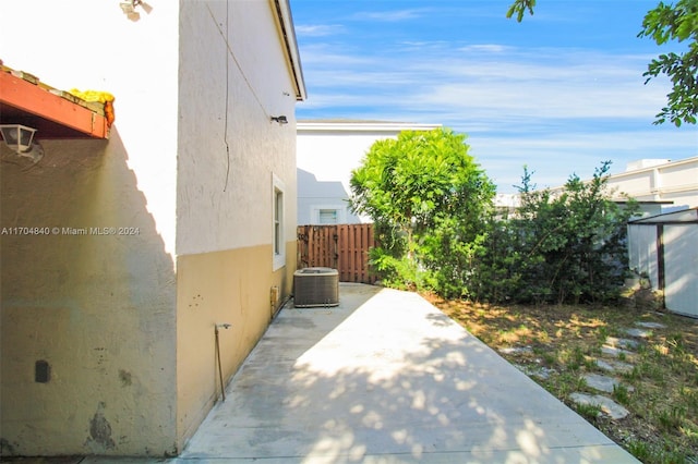 view of home's exterior with cooling unit, a patio area, fence, and stucco siding