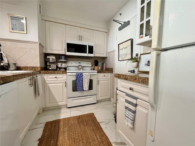 kitchen featuring white appliances, tasteful backsplash, white cabinetry, and sink