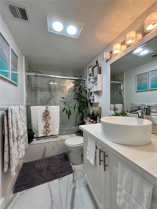 bathroom with vanity, toilet, and a shower with shower door