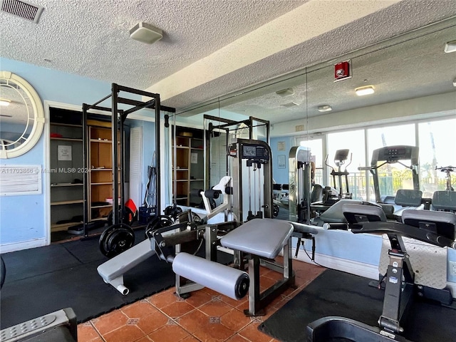 gym featuring tile patterned flooring and a textured ceiling