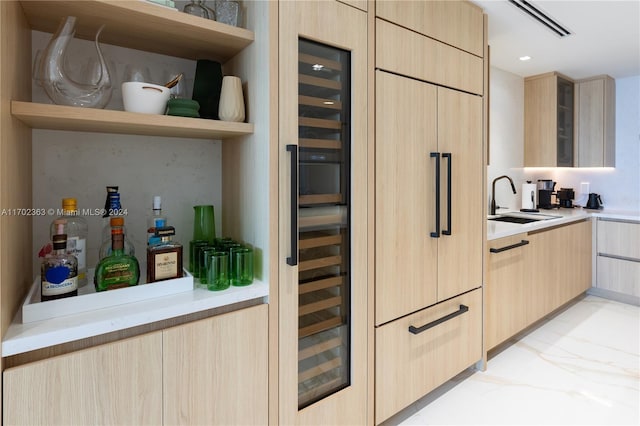 kitchen with light brown cabinets, wine cooler, and sink