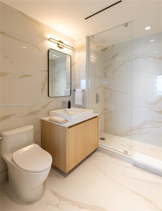 bathroom with a tile shower, vanity, tile walls, and toilet