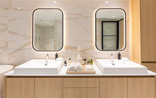 bathroom with vanity, backsplash, and tile walls