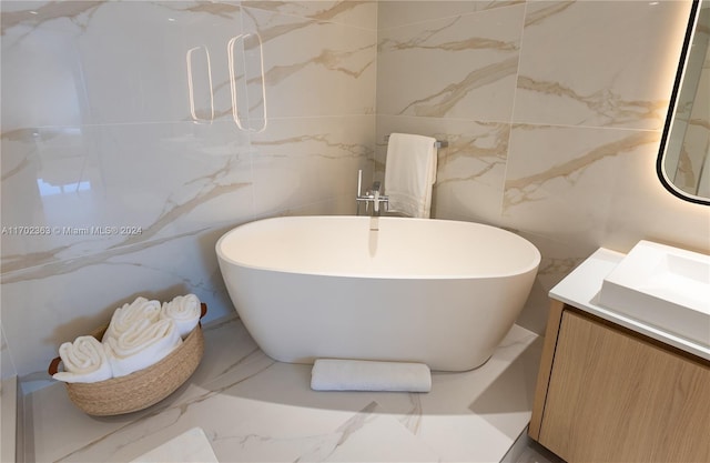 bathroom with vanity, a bath, and tile walls