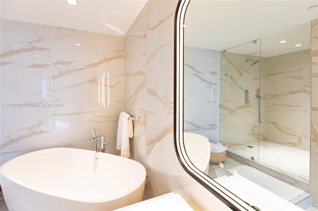 bathroom with tile walls and independent shower and bath