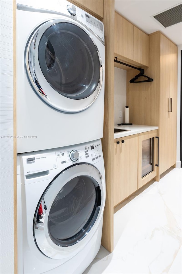 laundry area featuring stacked washer / dryer