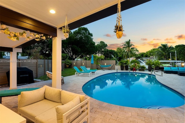 view of pool with an outdoor living space, a fenced in pool, fence, a patio area, and a grill