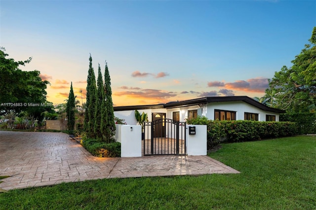 view of front of property featuring a yard, fence, and a gate